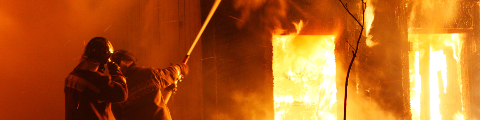 Firemen fighting in front of a building in fire