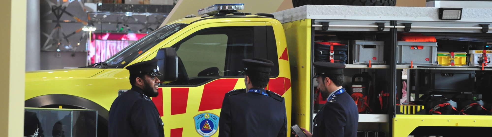 Officials in front of a civil defence vehicle at Milipol Qatar