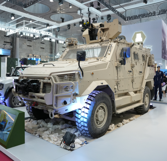 Armored military vehicle on display at Milipol Qatar 2024 exhibition with protective features and mounted equipment