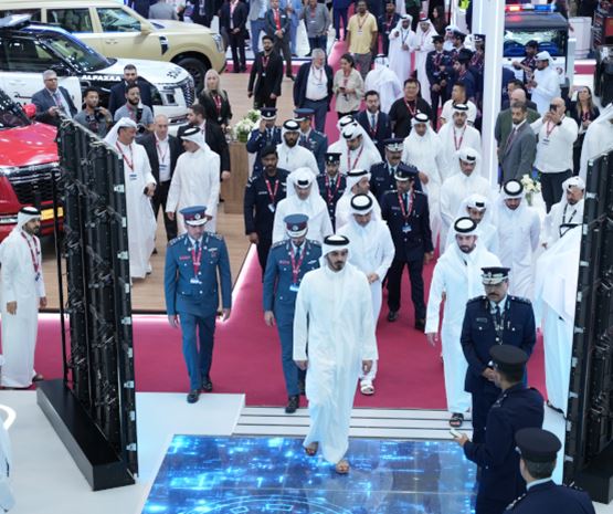 Group of officials in traditional and uniform attire walking the red carpet at the Milipol Qatar 2024 exhibition opening ceremony