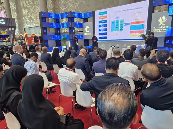 Audience attending a seminar at Milipol Qatar 2024 with presentation screen displaying security and technology content
