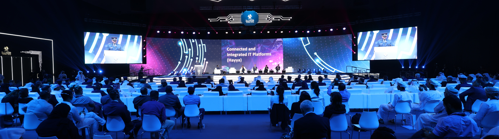 Global overview of the AI Summit room at Milipol Qatar 2024, with speakers seated on stage during a panel discussion in front of a large audience