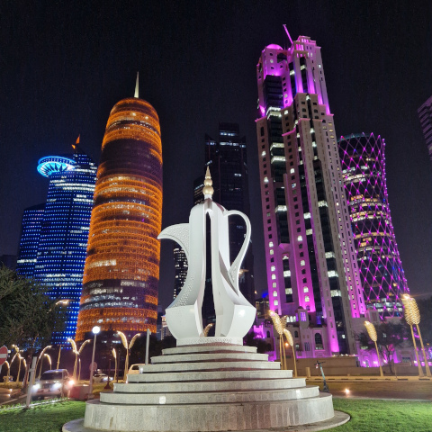 Sculpture in front of the Doha's skyline by night